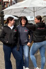 Drei Frauen Tragen den Lukasmarkt-Hoodie und die passende Weste