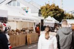 Krammarktstraße zum Lukasmarkt, in der sich viele Verkaufsstände unterschiedlicher Waren aneinanderreihen. Besucher laufen durch die Straße und stöbern an den Ständen
